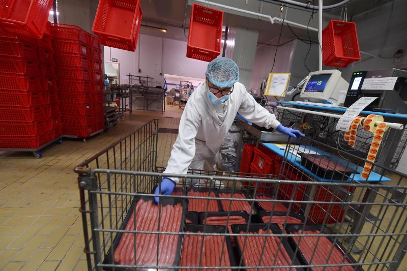 Employé de la Charcuterie des Flandres en train de travailler avec les produits