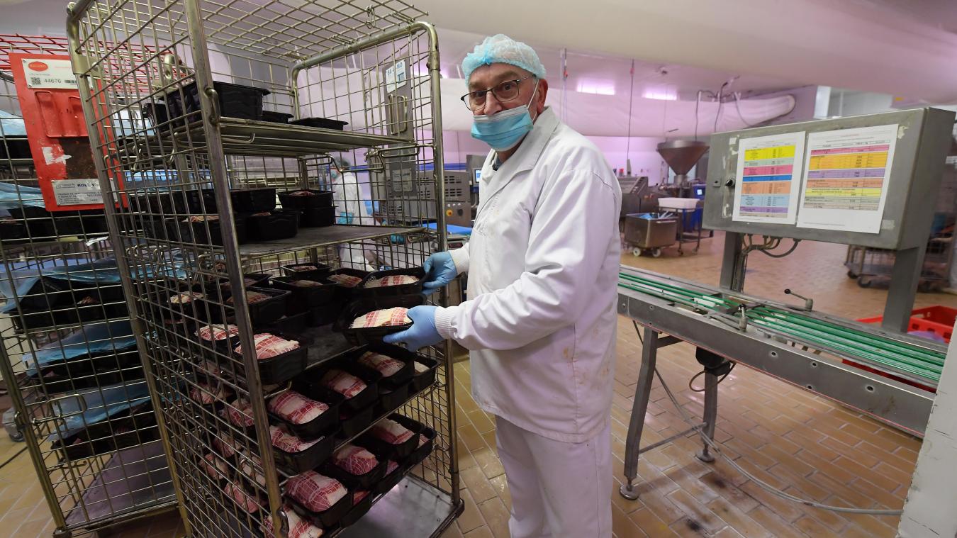 Employé de la Charcuterie des Flandres en train de travailler avec les produits